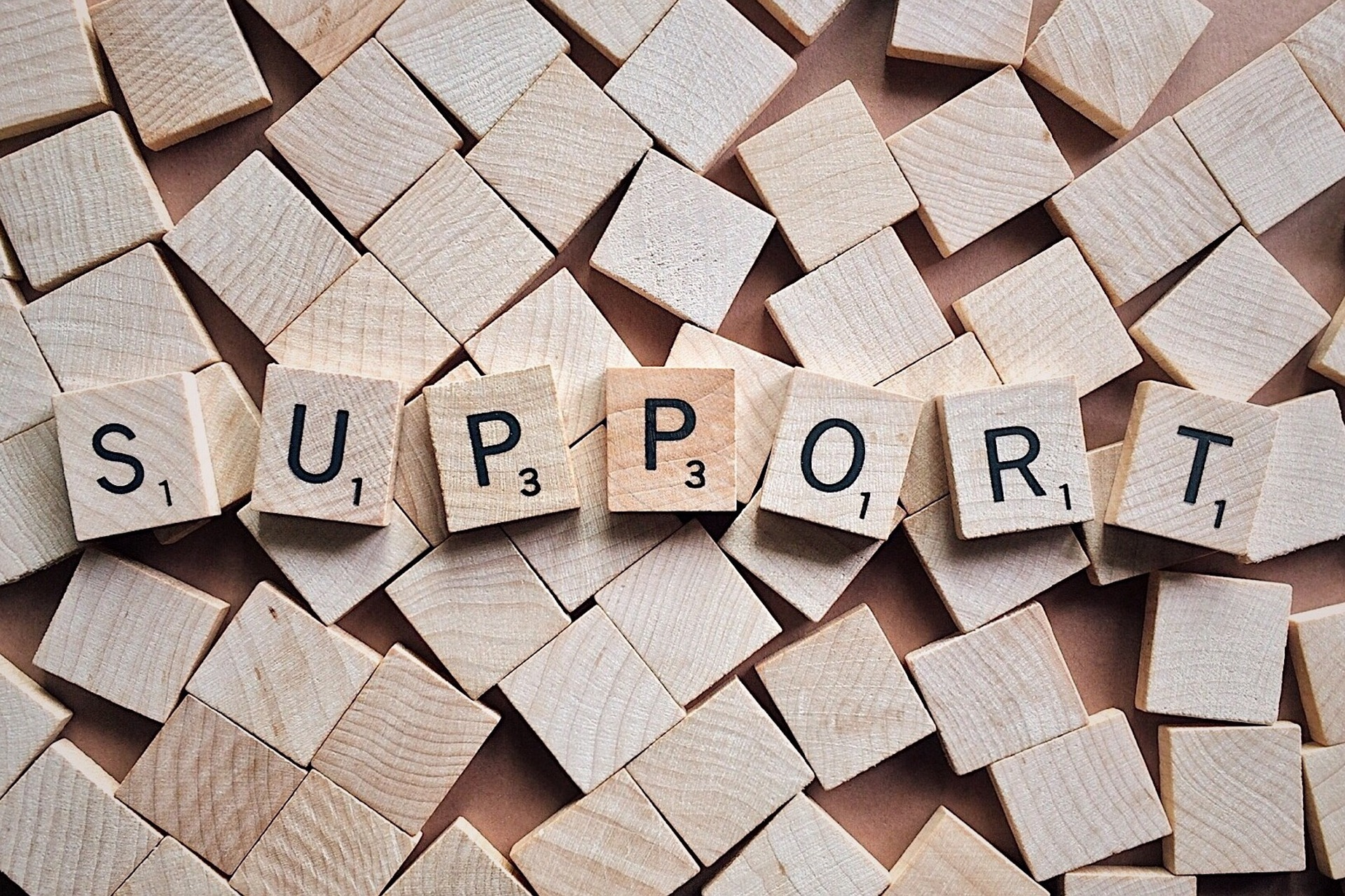 Scrabble-Steine, die das Wort Support bilden