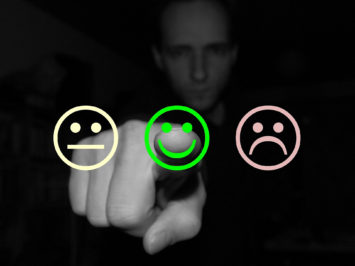 Mann vor Auswahl aus traurigen und frohen Smileys