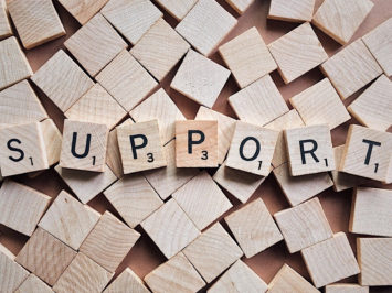 Scrabble-Steine, die das Wort Support bilden