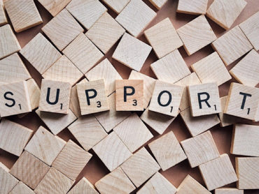 Scrabble-Steine, die das Wort Support bilden