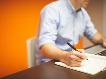 Mann, der Text mit Stift schreibt