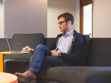 Mann auf Sofa am Laptop